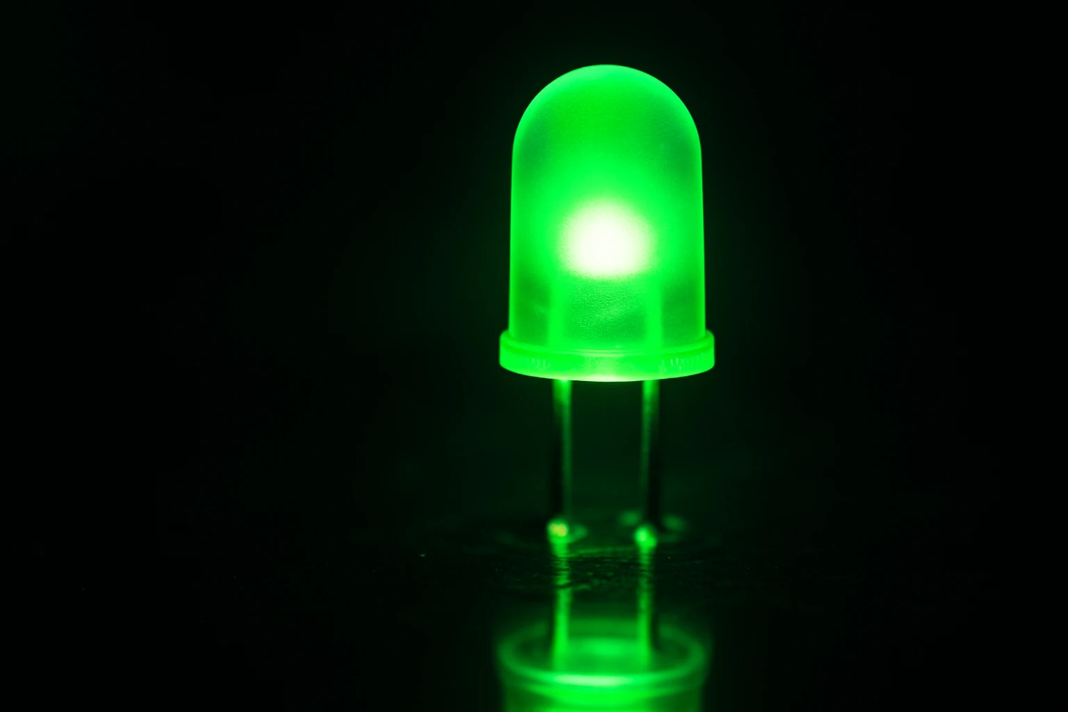A vivid, high-saturation green light glowing against a dark background, illustrating the electric, activating quality of Duolingo's signature green.